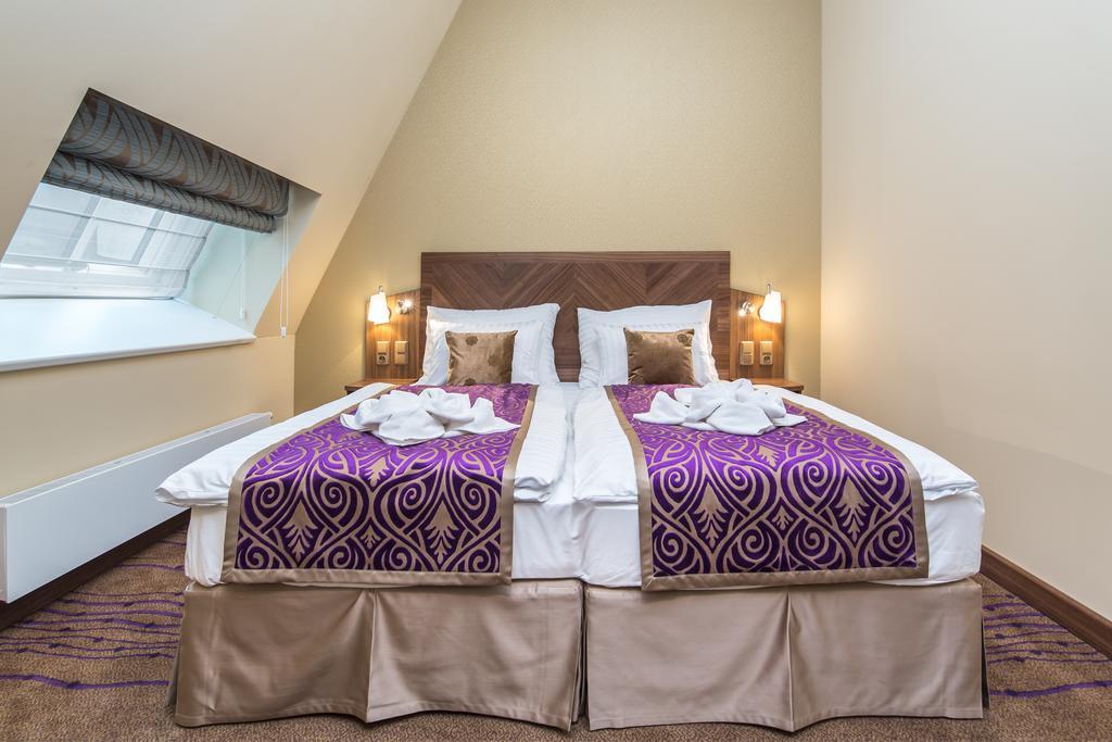 Merchants Crown Suites And Spa Praga Esterno foto A bed with a bed skirt